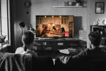 People sitting on a couch watching a pork commercial on TV